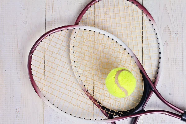 Heart shape made from tennis rackets. Close up on tennis racket and ball. Sport equipment background, wallpaper
