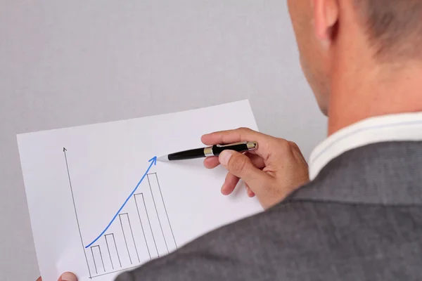 Close up to businessman hands showing  holding a rising arrow, representing business growth. Manager showing presentation of progressive arrow chart. Business vision, success, team work,  leadership c