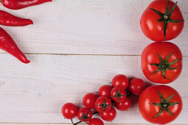 Cooking background. Colorful  Vegetables, Tomatos, ped pepper on white rustic wooden table. Recipe Planning Concept