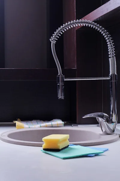 Close up of modern kitchen faucet and sink. Industrial style kitchen. House cleaning and home hygiene concept