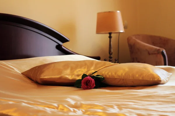 Honeymoon Suite Decoration. Hotel bed decorated with  rose flower. Luxury interior golden style