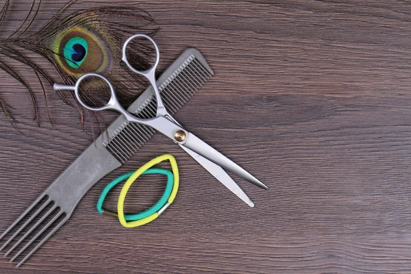 Scissors and comb on  wooden background. Hairdresser salon concept. Haircut  accessories