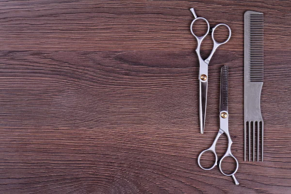Stylish Professional Barber Scissors, Hair Cutting and Thinning Scissors on wooden background. Hairdresser salon concept. Haircut accessories