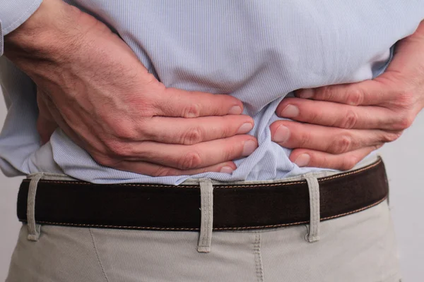 Close up of business man holding his lower back.  Man rubbing his painful back