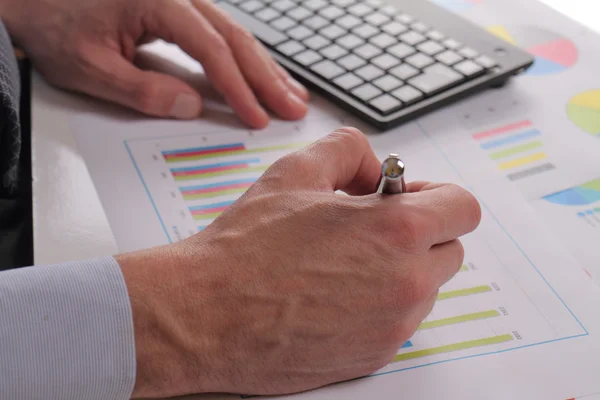 Close up of businessman working on  financial data in form of charts and diagrams. Business statistics and success concept