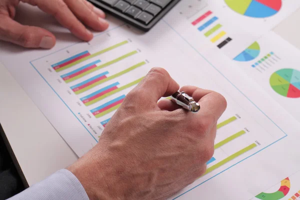 Close up of businessman working on  financial data in form of charts and diagrams. Business statistics and success concept