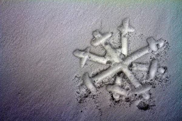 Snowflake drawn on dirty snow. Ecology and pollution concept