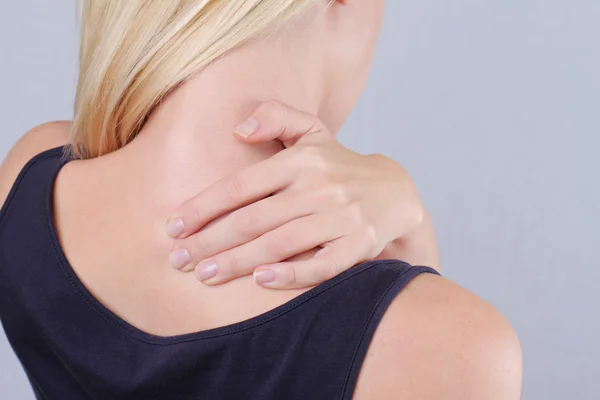 Woman with neck pain. Woman rubbing his painful neck close up. Pain relief concept