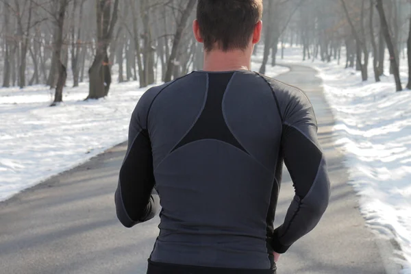 Man athlete running in forest on cold winter day. Running, jogging, sport, fitness, active lifestyle concept, cold weather training