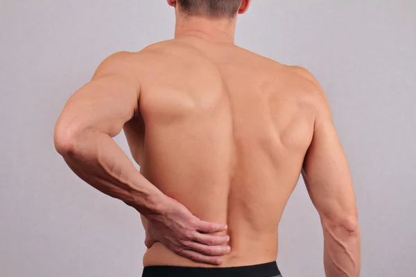 Man with back pain. Man rubbing his painful back close up. Pain relief concept
