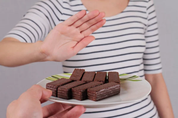 Diet concept. Woman refuses to eat chocolate sweets. Selective focus on chocolate