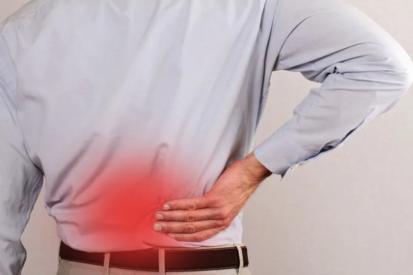 Business man holding his lower back.  Pain relief concept
