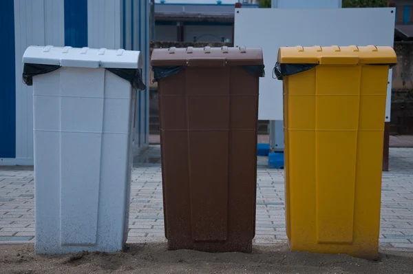 Garbage cans in white, brown and yellow