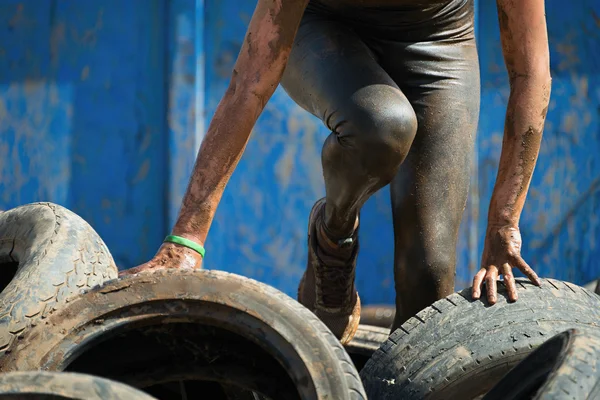 Mud race runners, tries to make it through the tire trap