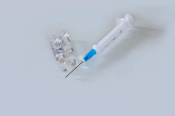Medical syringe and two ampoules on glass