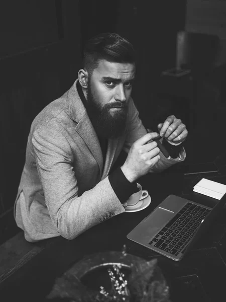 Attractive businessman is enjoying coffee with cigar