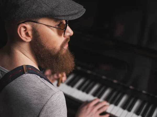 Talented bearded musician is playing the piano
