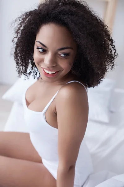 Cheerful mulatto girl is relaxing at home