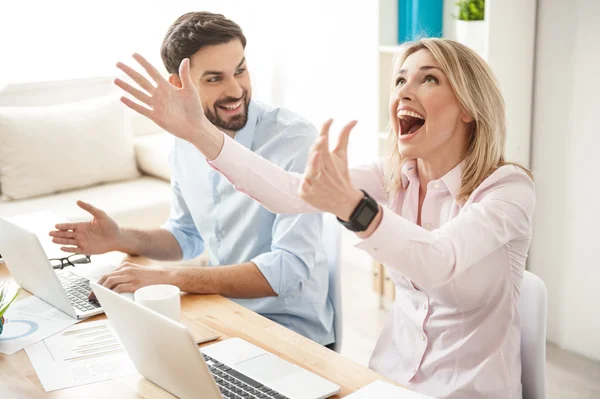 Successful two colleagues are expressing positive emotions