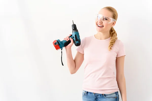 Smiling woman holding drill raising up