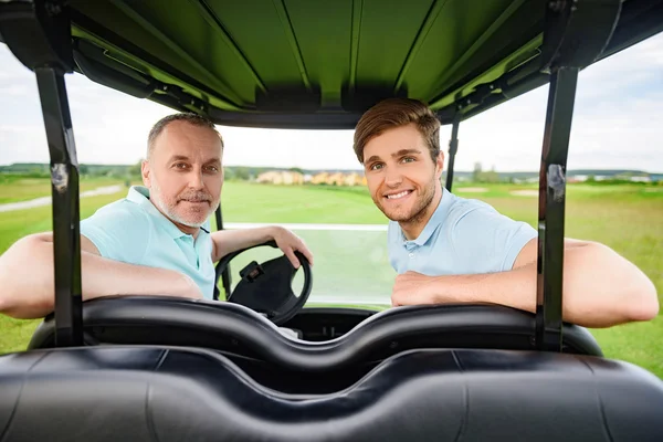 Two golfers sitting in cart