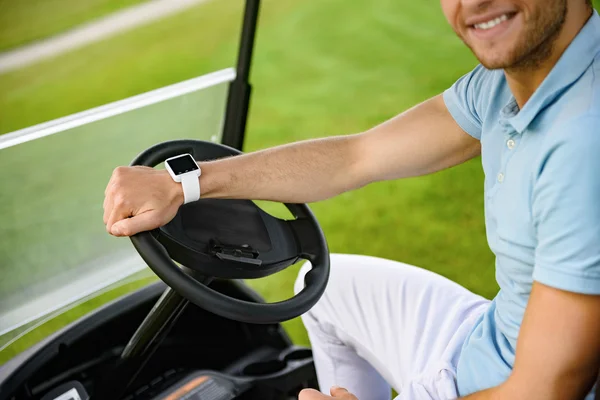 Smiling guy driving golf cart