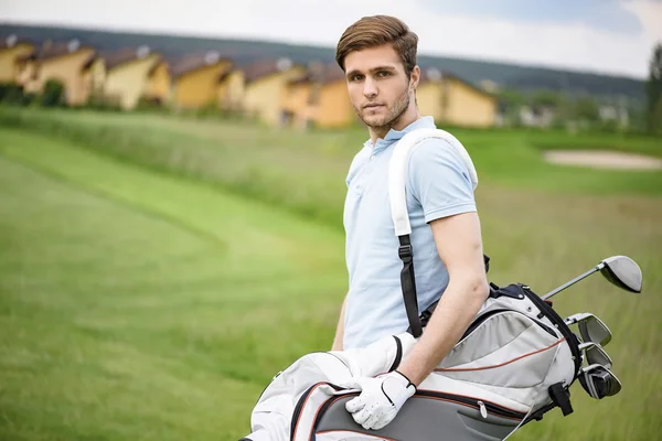 Young golfer holding golf bag