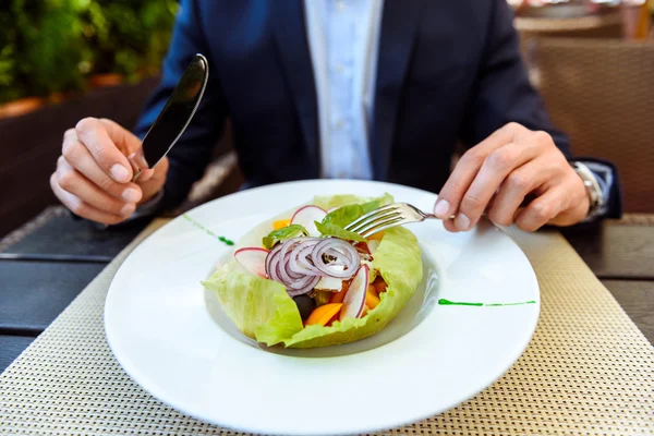 Hungry businessman eats healthy expensive food