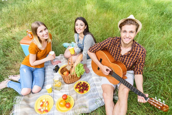 Cute friends making picnic in nature