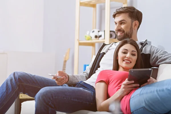 Man and woman watching tv on couch
