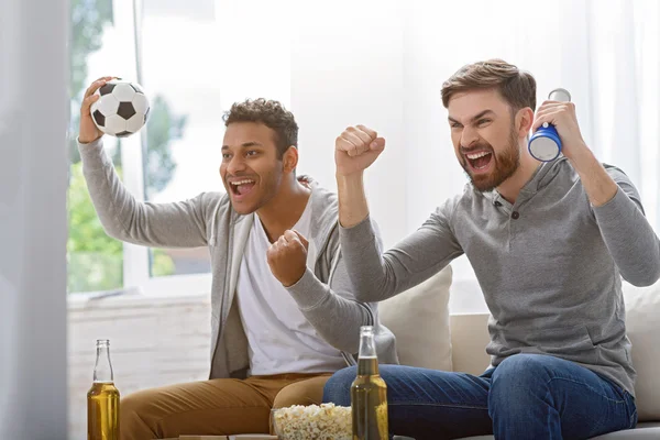 Friends enjoying soccer in TV