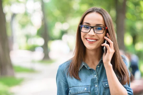 Happy young woman talking on telephone