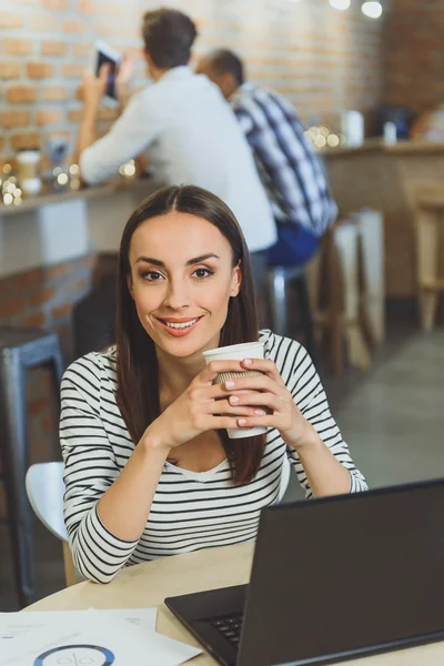 Joyful businesswoman making break in cafeteria