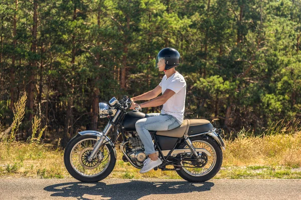 Young man riding his motorbike on open road