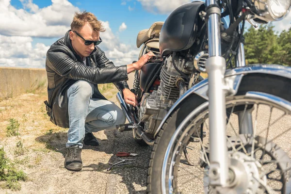 Young man repairing his bike