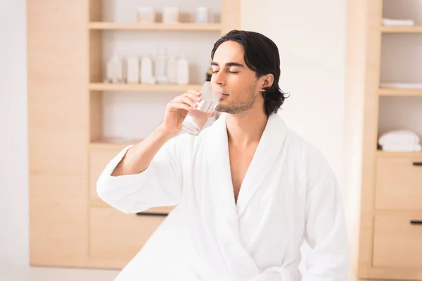 Tranquil guy is thirsty after massage