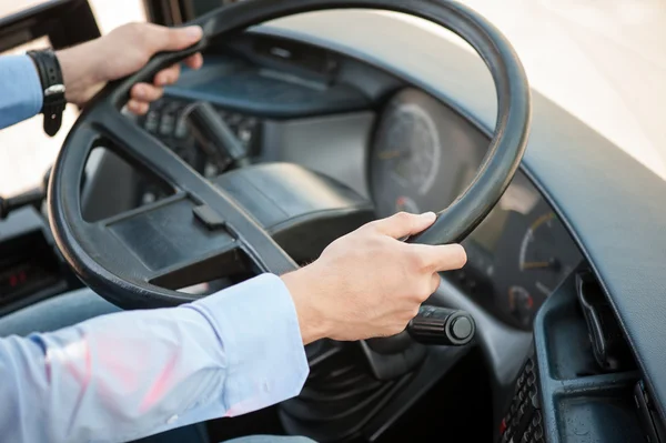 Young skilled man is driving a public transport