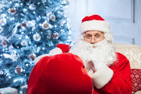 Old mysterious Father Christmas is gesturing secretly
