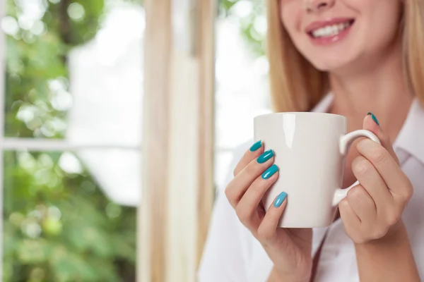 Attractive young woman is enjoying hot drink