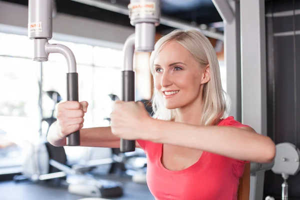 Attractive young woman is training in fitness center