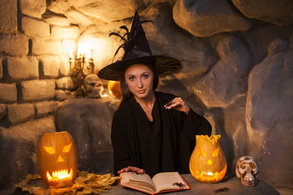 Cheerful young witch is conjuring in Nut-Crack Night