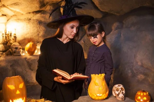 Cheerful female wizard is teaching child to conjure