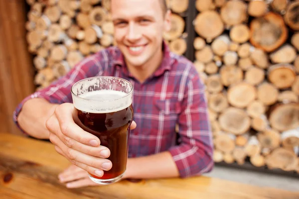 Cheerful man is swigging lager in pub