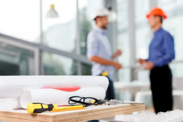 Professional male engineers are talking at office