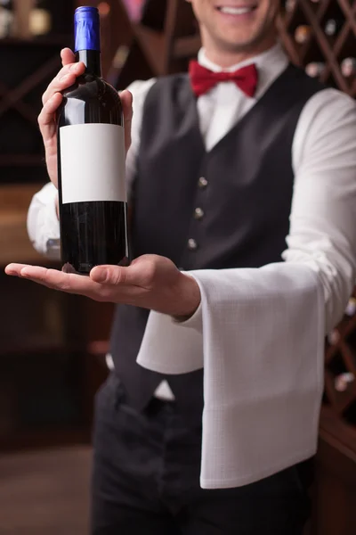 Cheerful young sommelier is showing perfect beverage