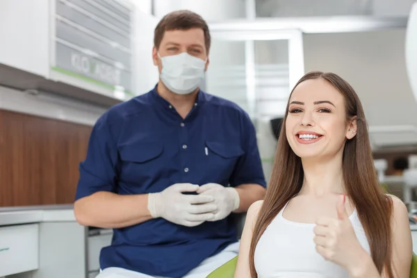 Attractive young dental doctor is treating his patient