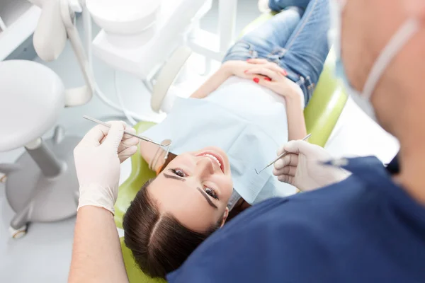 Experienced young dental doctor is examining female teeth