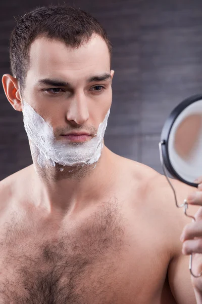 Attractive young guy with foam for shave