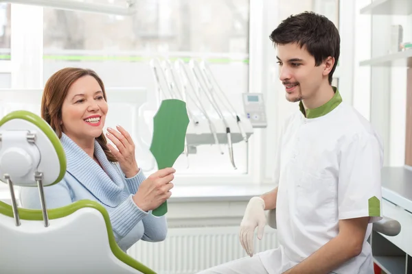 Skillful male dental doctor is working with patient