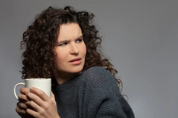 Cheerful young girl with a cup of tea